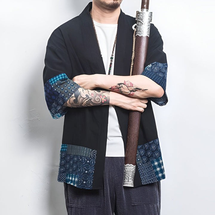 Homme portant un kimono noir à motifs bleus, tenant un sabre. Vêtements japonais traditionnels. Kimonos pour hommes. Mode asiatique et art martial. Style vestimentaire unique. Découvrez notre collection de kimonos.