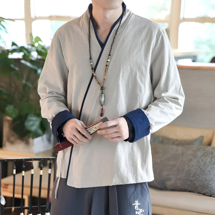Homme portant un kimono beige à manches longues avec finitions bleues. Collier de perles et éventail. Kimono traditionnel en vente.