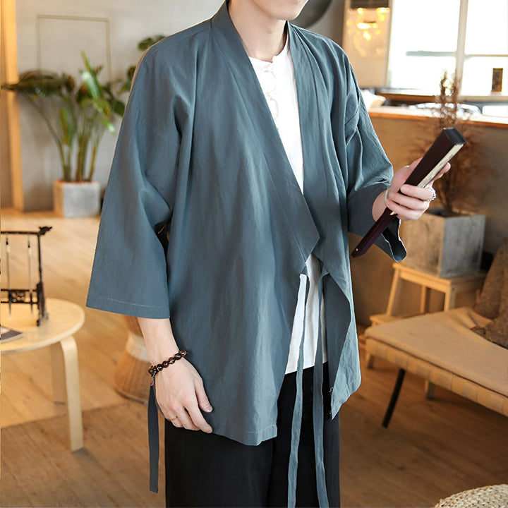 Homme portant un kimono bleu-gris avec des manches amples. Vente de kimonos pour hommes. Vêtements japonais traditionnels et modernes. Mode inspirée de l'Asie.
