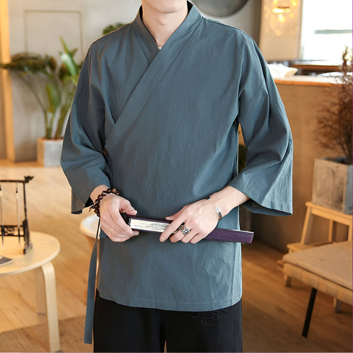 Homme portant un kimono bleu-gris ample avec des manches larges. Vente de kimonos traditionnels et modernes pour hommes et femmes. Découvrez notre collection de vêtements japonais authentiques.