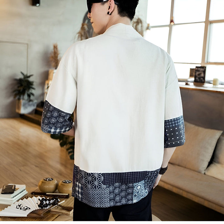 Dos d'un homme portant un kimono blanc avec motifs japonais bleus aux manches et à l'ourlet. Vêtements traditionnels japonais à la mode. Découvrez notre collection de kimonos uniques.