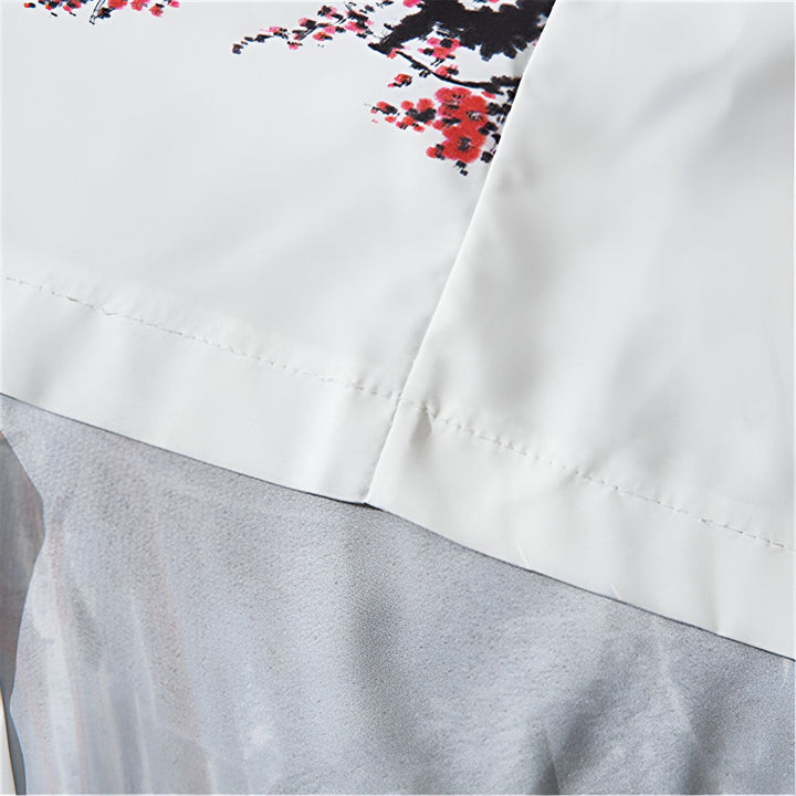 Détail d'un kimono blanc avec motif floral japonais rouge et noir. Couture soignée. Kimonos traditionnels et modernes à découvrir.