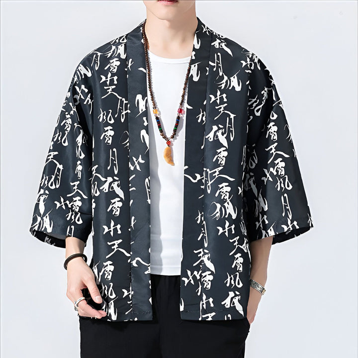 Homme portant un kimono noir à motifs calligraphiques blancs. Vente de kimonos pour hommes. Style japonais traditionnel revisité. Mode homme, vêtement d'extérieur.