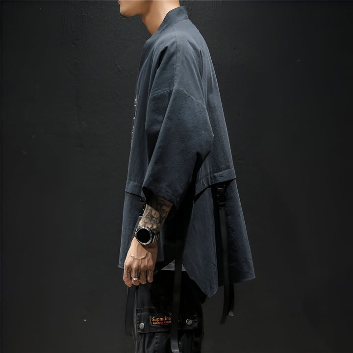 Homme portant un kimono noir avec des sangles et un pantalon cargo. Vêtements de style japonais à la mode. Kimono unisexe à vendre en ligne.