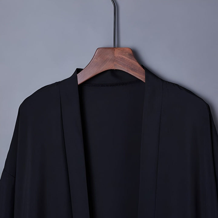 Kimono noir élégant suspendu à un cintre en bois. Vêtement traditionnel japonais. Idéal pour la mode, le style et le confort. Achetez votre kimono dès aujourd'hui !