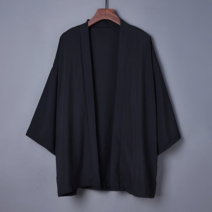 Kimono noir pour homme sur un cintre en bois. Vêtements traditionnels japonais. Découvrez notre collection de kimonos uniques.