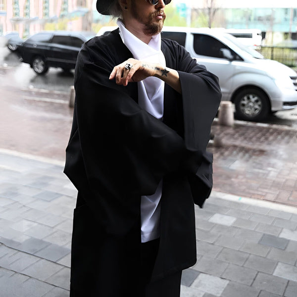 Homme portant un kimono noir avec un foulard blanc, lunettes de soleil et chapeau. Kimonos modernes et traditionnels en vente.