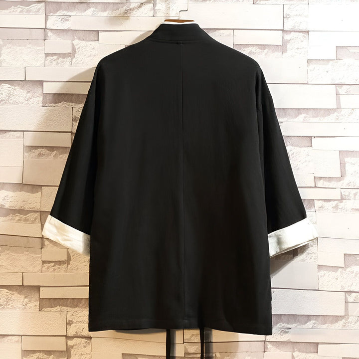 Vue arrière d'un kimono noir avec des poignets blancs, style japonais traditionnel. Vêtements amples et élégants de notre collection de kimonos.