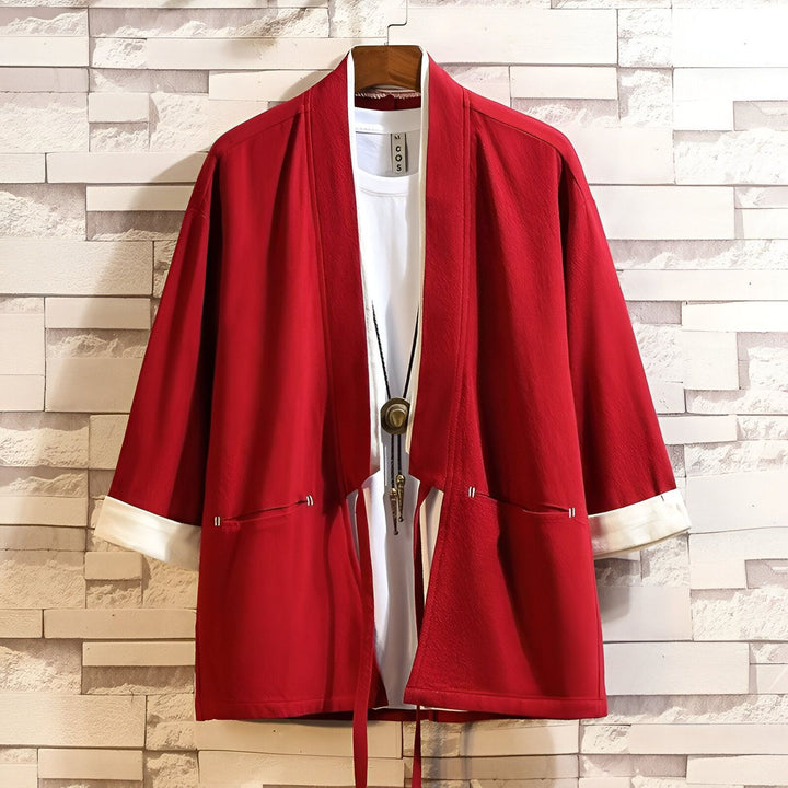 Kimono rouge en lin avec manches blanches, porté ouvert sur un t-shirt blanc et un collier. Vêtement traditionnel japonais, idéal pour un look décontracté et élégant. Découvrez notre collection de kimonos uniques.