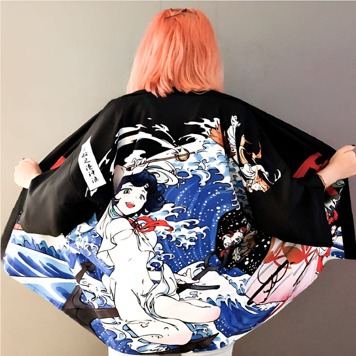 Kimono noir avec imprimé de manga et vagues japonaises bleues, porté par une femme aux cheveux roses. Vêtements japonais traditionnels et modernes. Boutique en ligne de kimonos pour femmes.