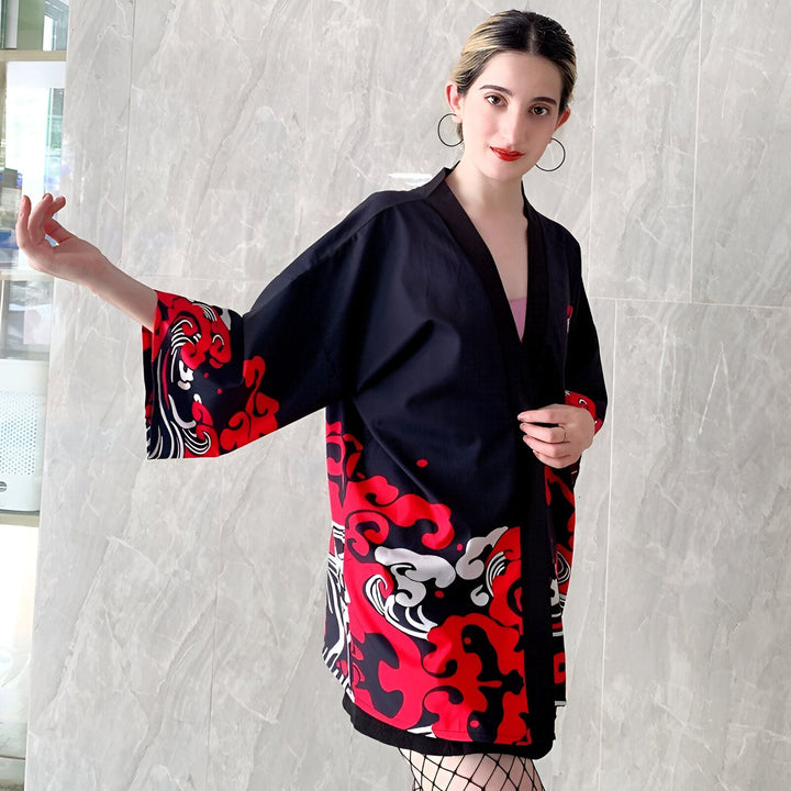 Femme portant un kimono noir avec motifs rouges et blancs. Kimono à manches larges, style japonais moderne. Mode kimono, vêtements traditionnels revisités. Boutique de kimonos en ligne.