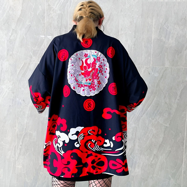 Dos d'une personne portant un kimono noir orné d'un motif de masque japonais rouge et de nuages stylisés rouges. Vêtements traditionnels japonais à vendre.