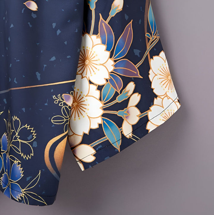 Détail d'un kimono bleu marine avec motif floral blanc, bleu et doré. Vêtement traditionnel japonais élégant.