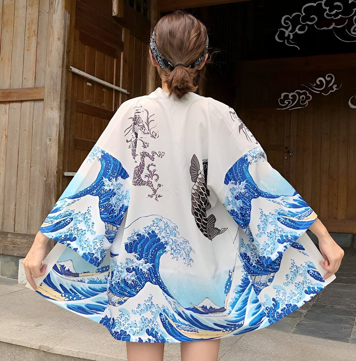 Vue arrière d'une femme portant un kimono blanc avec des motifs japonais : vagues bleues, carpe koï noire et dragon. Kimono de style japonais.