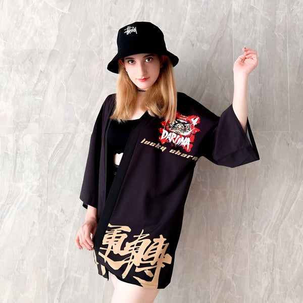 Femme portant un kimono noir avec des motifs japonais, chapeau noir. Vêtements de style kimono à vendre.
