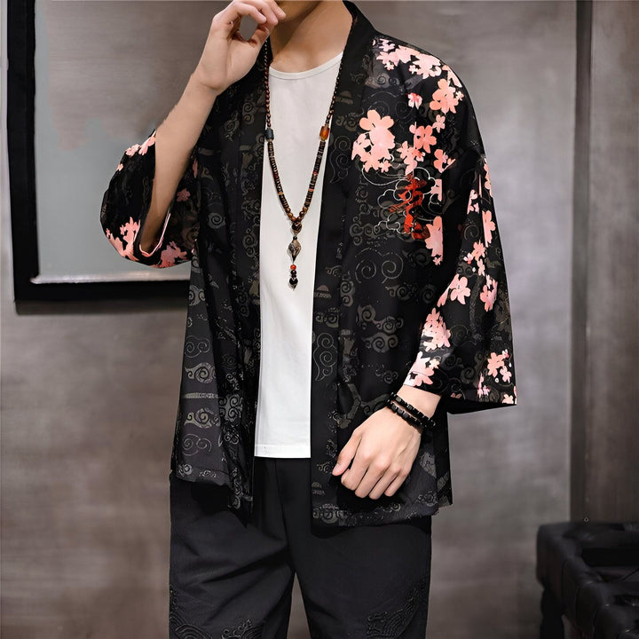 Homme portant un kimono noir avec motifs floraux roses. Vêtements japonais traditionnels et modernes à vendre.