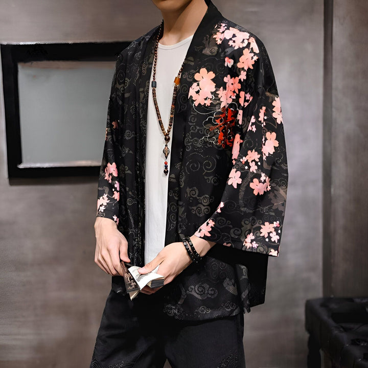 Homme portant un kimono noir à motifs floraux roses et blancs. Vente de kimonos pour hommes. Style japonais traditionnel et moderne. Mode masculine.