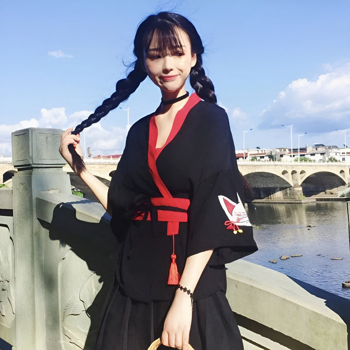 Jeune femme portant un kimono noir et rouge avec motif de renard. Vente de kimonos japonais traditionnels et modernes. Style japonais.