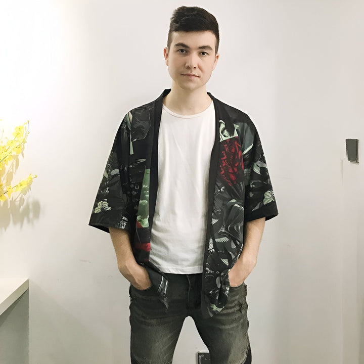 Homme portant un kimono noir imprimé, style japonais moderne. Kimono homme tendance, parfait pour un look décontracté. Découvrez notre collection de kimonos uniques en ligne.