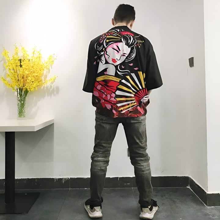 Homme portant un kimono noir avec une geisha imprimée au dos. Vêtements japonais traditionnels en vente.