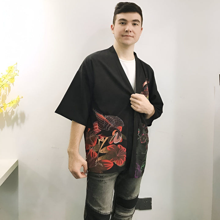 Homme portant un kimono noir avec des motifs de grues et de fleurs rouges. Kimonos pour hommes disponibles à l'achat. Vêtements japonais traditionnels et modernes.