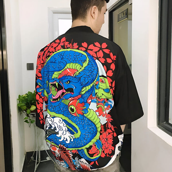 Homme portant un kimono noir avec un grand motif de dragon bleu, carpe koï et fleurs rouges. Vêtement de style japonais, idéal pour un look unique et tendance. Découvrez notre collection de kimonos authentiques.