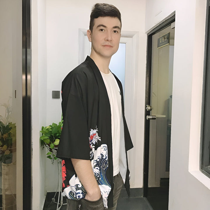 Homme portant un kimono noir à motifs de vagues et de carpes koï. Kimonos pour hommes disponibles à l'achat. Vêtements traditionnels japonais revisités. Découvrez notre collection de kimonos.
