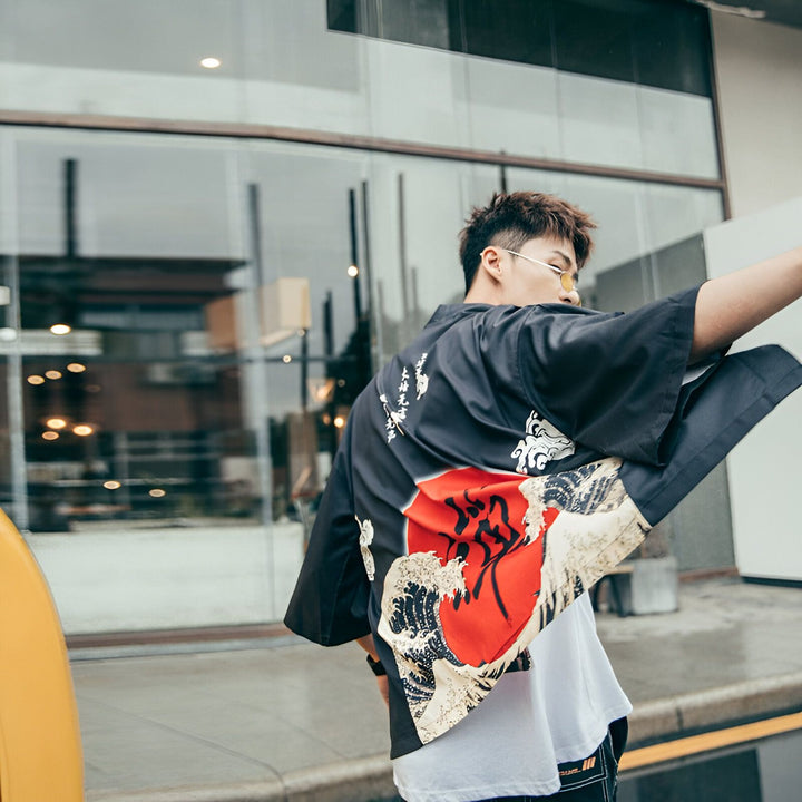Homme portant un kimono noir imprimé avec un soleil rouge et des vagues. Vente de kimonos japonais modernes. Mode et style d'inspiration asiatique. Nouveau kimono tendance.