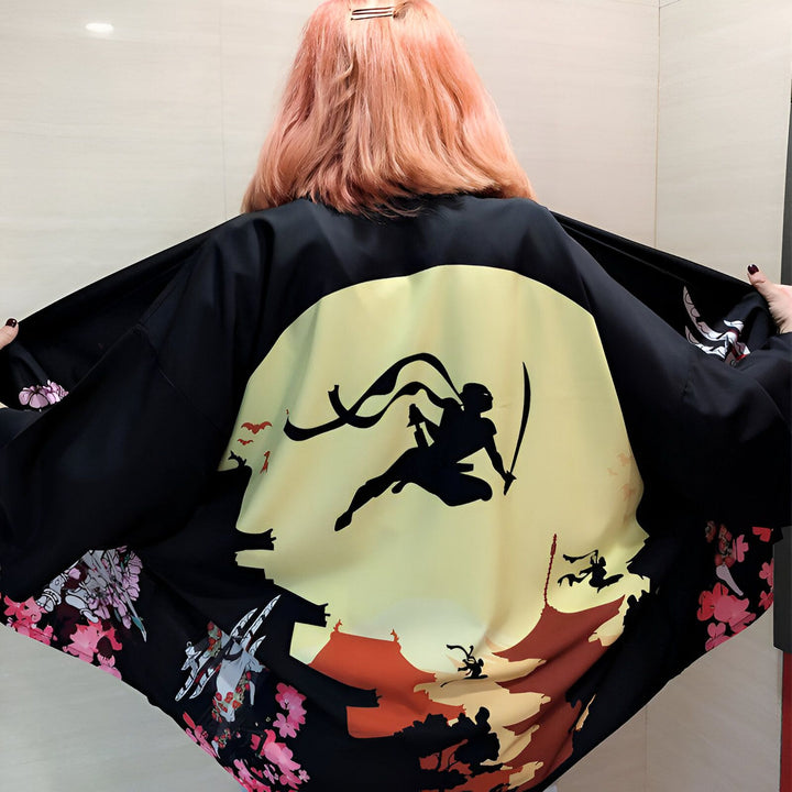 Kimono noir avec motif ninja et fleurs, vue arrière. Vêtements japonais traditionnels et modernes. Découvrez notre collection de kimonos uniques.