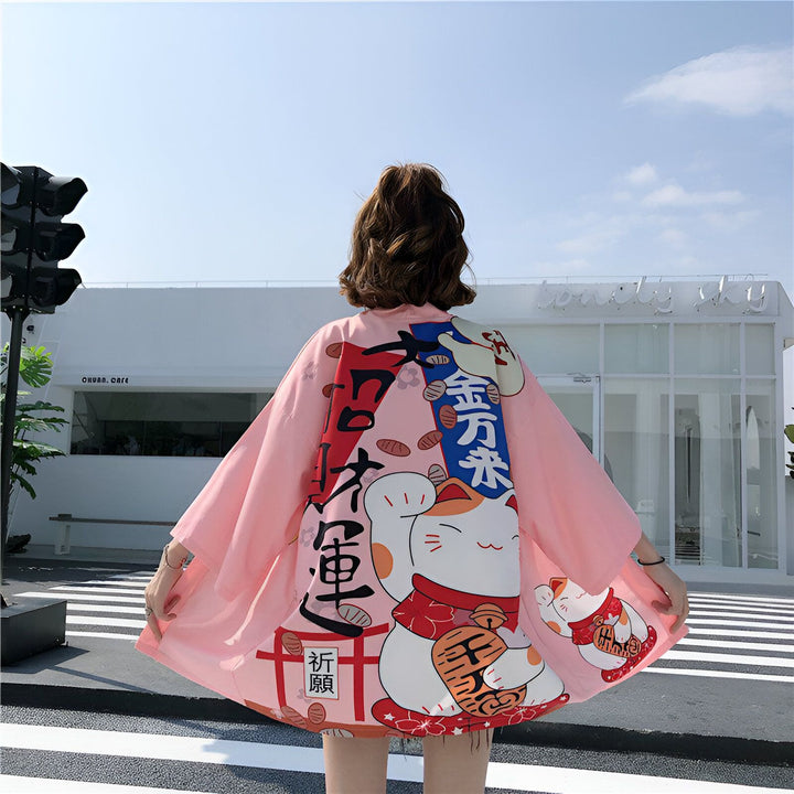 Kimono rose avec motif de chat porte-bonheur japonais. Vêtements japonais traditionnels et modernes à la fois. Découvrez notre collection de kimonos uniques.