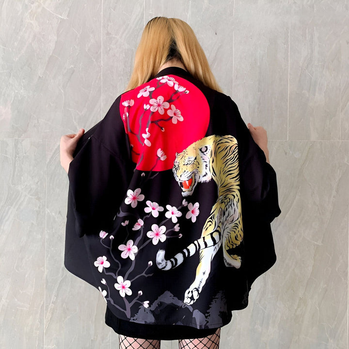Kimono noir avec imprimé tigre, lune rouge et fleurs de cerisier. Vêtement de style japonais pour hommes et femmes, disponible dans notre boutique. Mode japonaise.