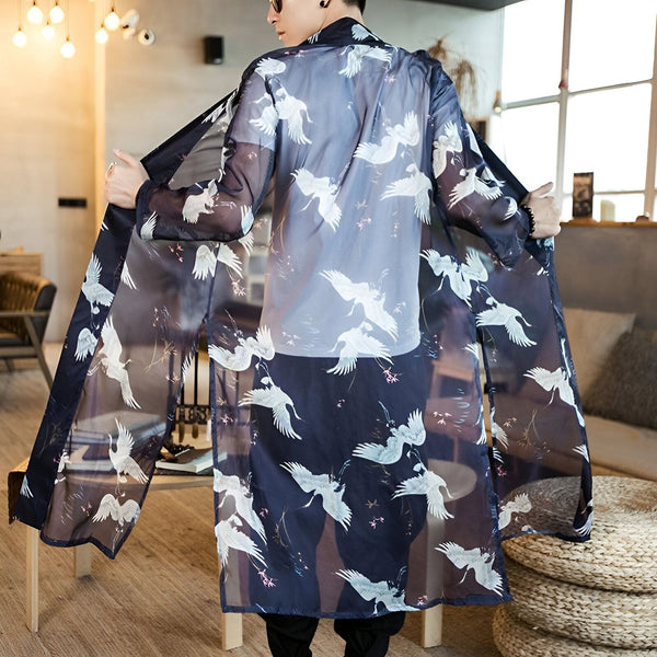 Homme portant un kimono long et transparent à motifs de grues blanches. Kimonos disponibles à l'achat.