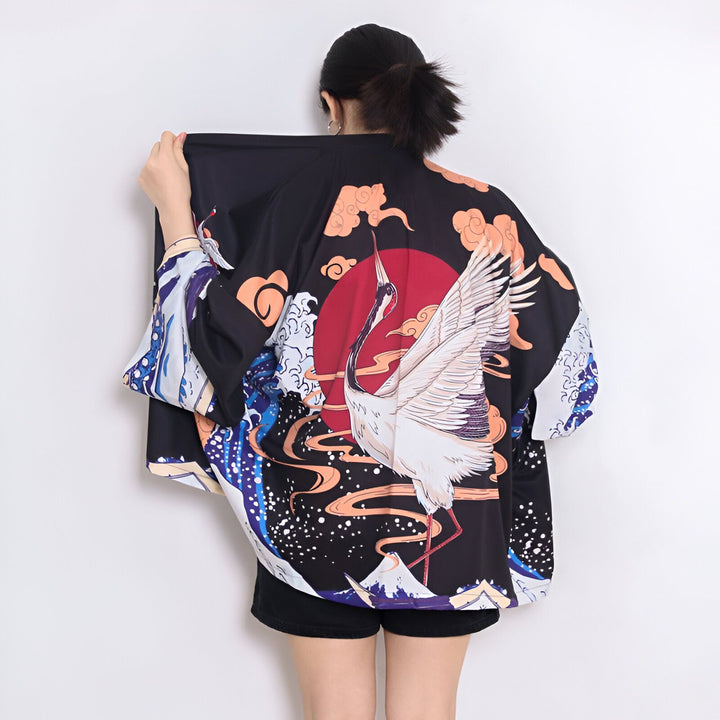 Kimono noir avec motif de grue blanche et soleil rouge, style japonais traditionnel. Vêtement unique pour un look original. Découvrez notre collection de kimonos.