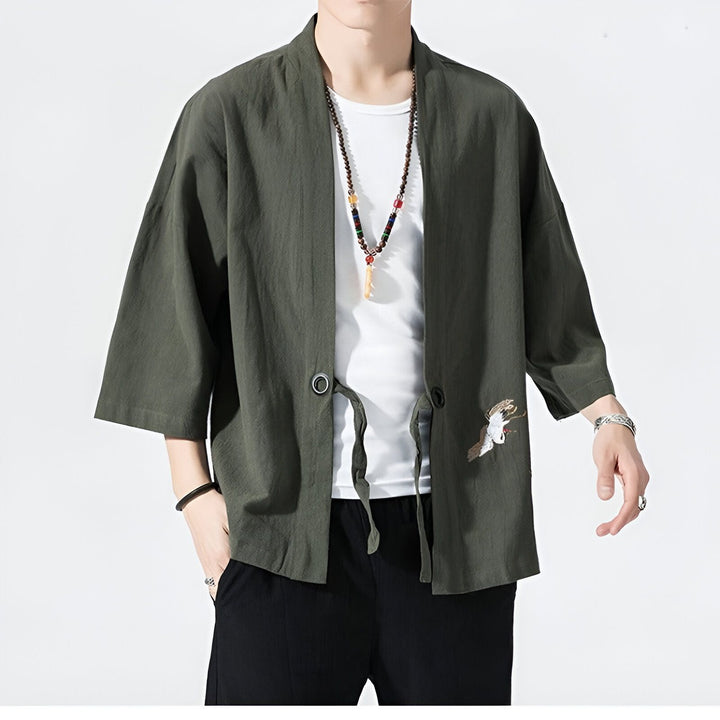 Homme portant un kimono vert olive avec broderie de grue. Vente de kimonos pour hommes et femmes. Style japonais traditionnel et moderne.