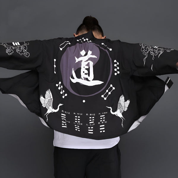 Homme portant un kimono noir avec imprimés grues, yin-yang et calligraphie. Vêtements de style japonais, kimono tendance.
