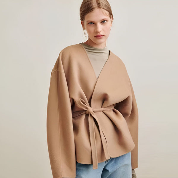 Femme portant un kimono beige élégant avec ceinture nouée. Découvrez notre collection de kimonos uniques.