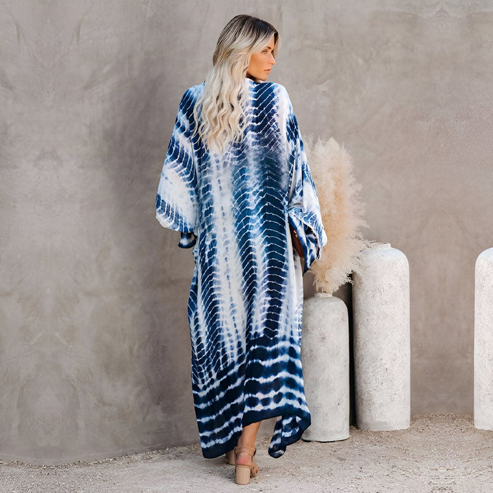 Femme portant un kimono long tie-dye bleu et blanc. Vue arrière d'une cliente portant un kimono de notre collection. Achetez des kimonos élégants en ligne.