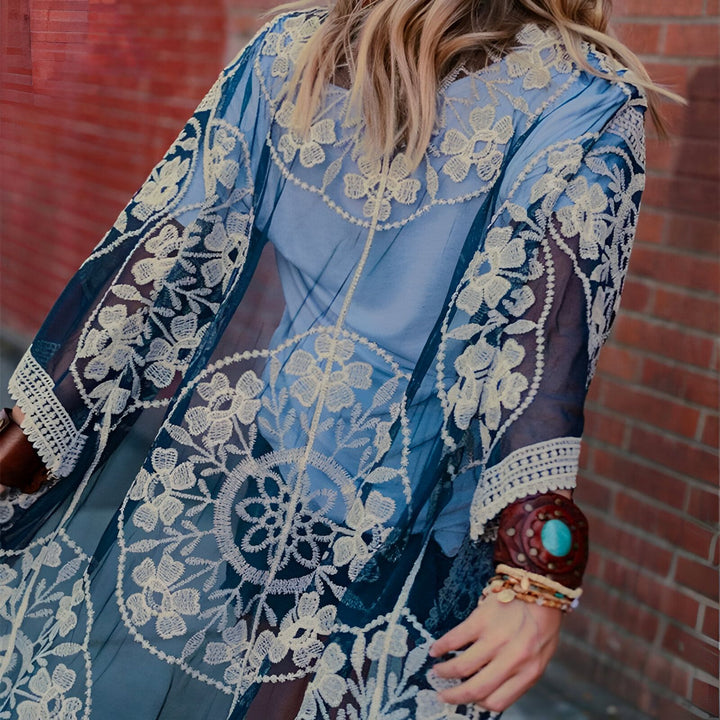 Kimono long bleu en dentelle florale, porté par une femme. Vêtements de plage, style bohème chic. Collection de kimonos pour femmes.