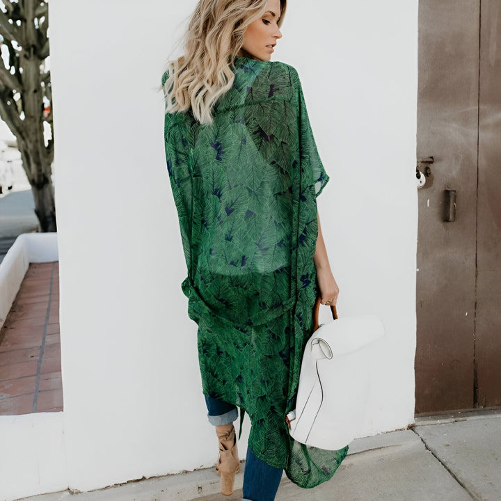 Femme portant un kimono vert transparent à motifs de feuilles, avec un sac à main blanc. Vêtements d'été à la mode, style décontracté. Kimonos en vente.