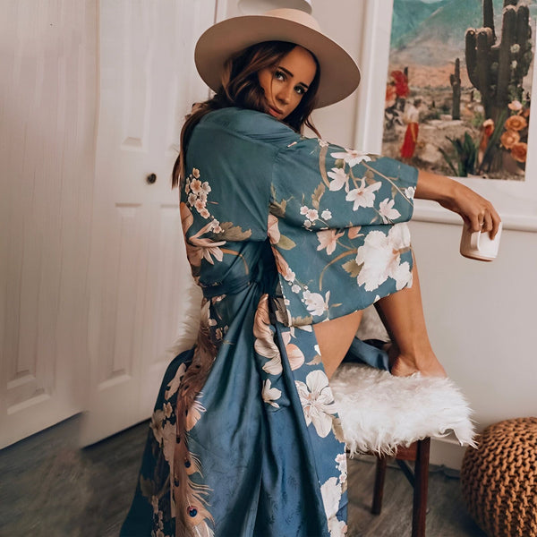 Femme portant un kimono bleu à motifs floraux et un chapeau. Kimono tendance, vêtement d'intérieur confortable. Notre collection de kimonos uniques.