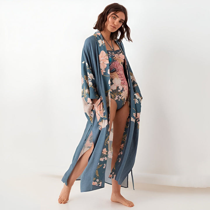 Femme portant un kimono bleu à motifs floraux, collection de kimonos sur notre site. Idéal pour la plage ou comme vêtement d'intérieur.