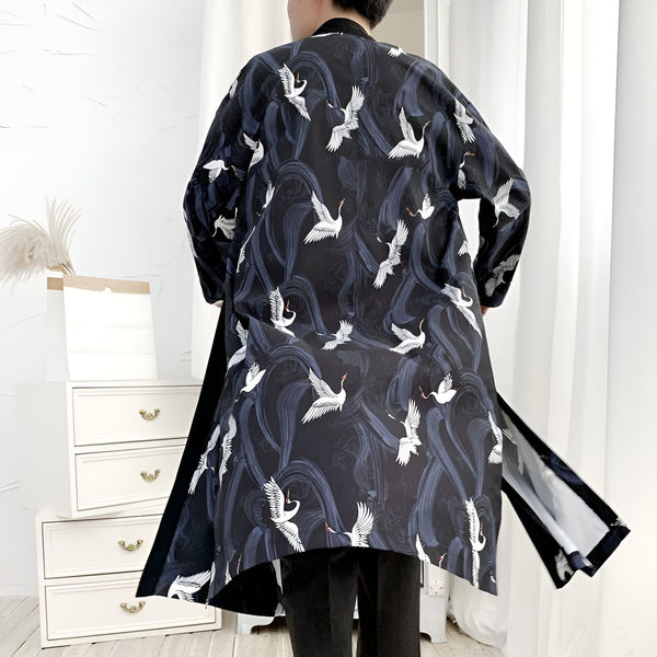 Homme portant un kimono long noir avec motif de grues blanches et vagues bleues. Kimono japonais traditionnel à vendre.