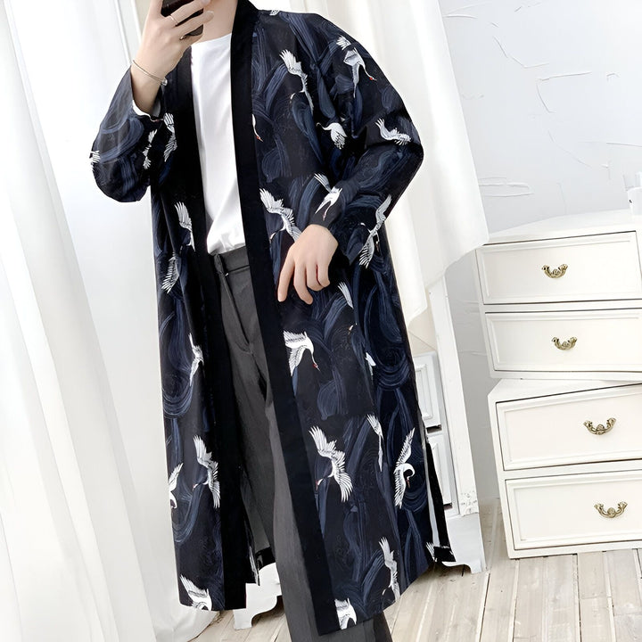Homme portant un kimono long bleu marine avec motif de grues blanches. Vêtements japonais traditionnels à la mode.