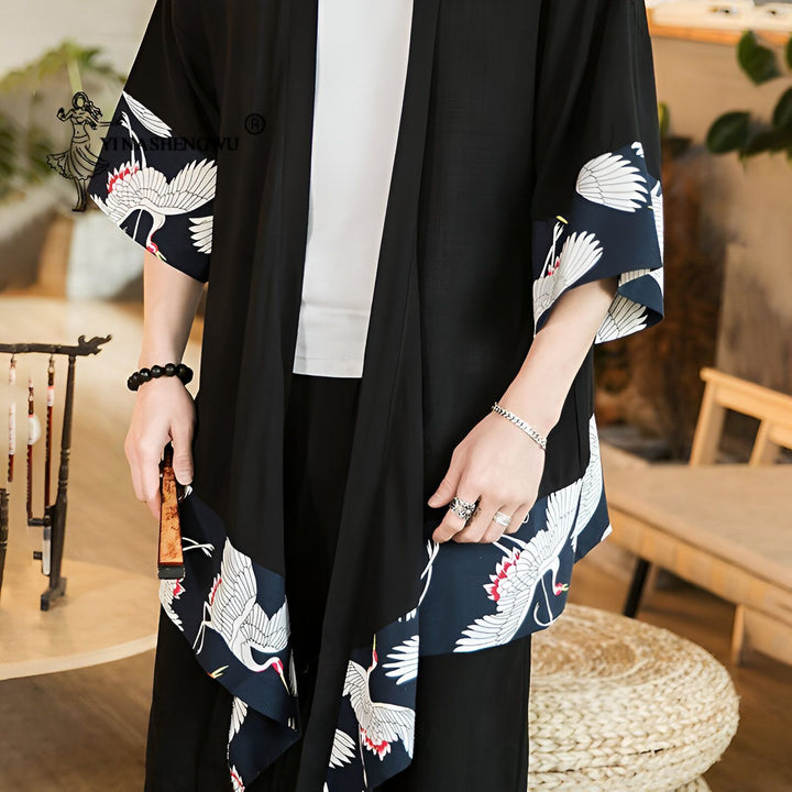 Homme portant un kimono noir avec motifs de grues blanches. Vêtements de style japonais, kimono traditionnel. Mode asiatique, produit en vente dans notre boutique en ligne.