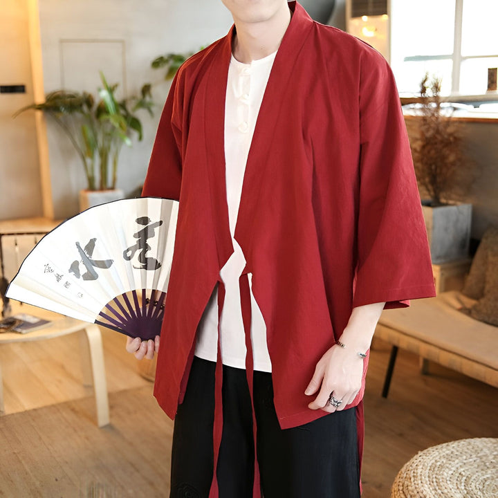 Homme portant un kimono rouge avec un éventail japonais. Vêtements traditionnels japonais à vendre.