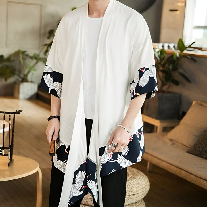 Homme portant un kimono blanc avec des motifs de grues japonaises sur les manches et le bas. Kimonos élégants et confortables à découvrir dans notre boutique.
