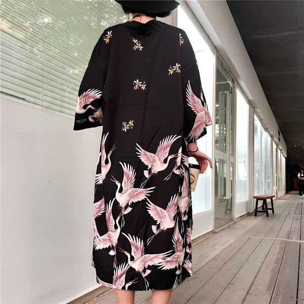 Kimono noir long avec motifs de grues roses et fleurs. Vêtements traditionnels japonais. Boutique de kimonos authentiques. Style unique et élégant.