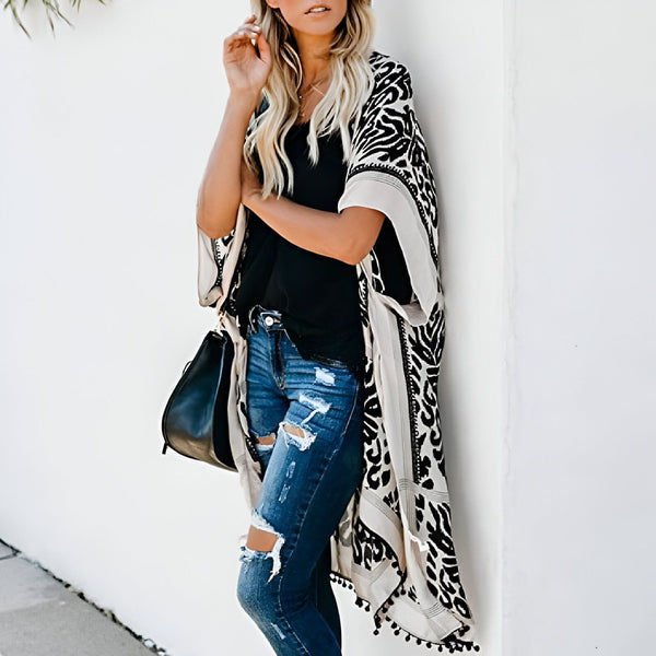 Femme portant un kimono à motifs noir et blanc, avec un jean déchiré et un sac noir. Vêtements de style kimono pour femmes. Boutique de kimonos en ligne. Nouveau modèle de kimono tendance.