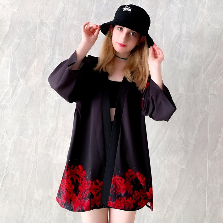 Jeune femme portant un kimono noir à fleurs rouges. Vêtements traditionnels japonais en vente.