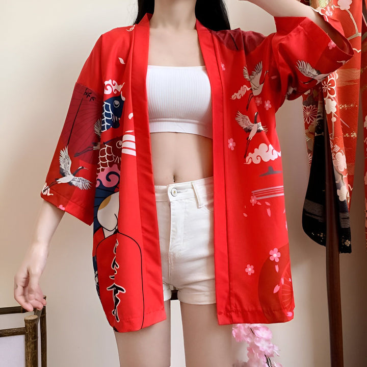 Kimono rouge avec motifs japonais (grues, fleurs) porté par une femme. Vêtements japonais traditionnels.